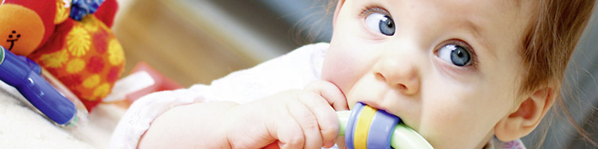 Child putting a plastic toy in her mouth