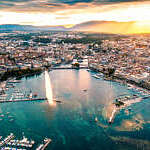 high angle view of Geneva city panoramic from drone point at sunset with famous travel destination jet d'eau and Geneva Lake.