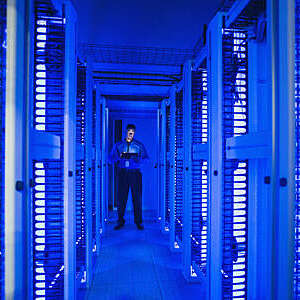 Black businessman using digital tablet in server room