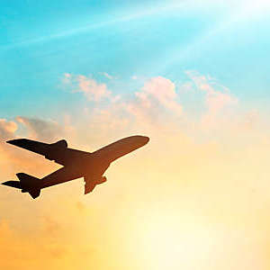 Airplane in the sky with clouds at sunset.